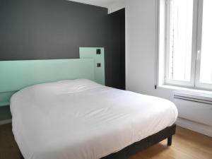 a white bed in a bedroom with a window at Le Chat Qui Dort in Lille
