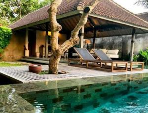 uma villa com uma piscina e uma casa em Komea Villa em Canggu