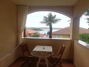 a table and chairs in a balcony with a palm tree at Apartment Rustica in Portorož