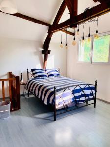 een slaapkamer met een bed met blauwe en witte lakens bij Gîte de la Vernière in Payrignac