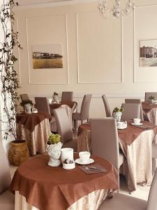 a dining room with tables and chairs and a chandelier at Hotel Regina Margherita in Bordighera