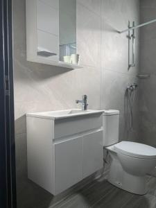 een witte badkamer met een wastafel en een toilet bij Ayia Napa Boutique Apartments in Ayia Napa