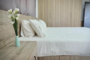 a blue vase with white flowers sitting on a bed at Ayia Napa Boutique Apartments in Ayia Napa