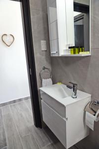 a bathroom with a white sink and a mirror at Ayia Napa Boutique Apartments in Ayia Napa