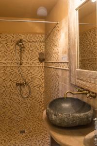 a bathroom with a stone sink and a shower at Marie Colline à la Campagne in Saint-Antonin