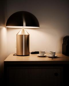 a lamp sitting on a table with two cups at Hôtel Le Windsor Biarritz in Biarritz