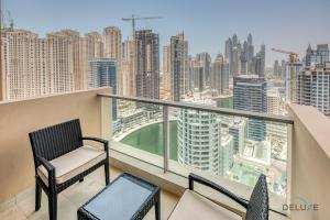 a balcony with two chairs and a view of a city at Exquisite 1BR at The Address Residences Dubai Marina by Deluxe Holiday Homes in Dubai