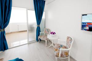 ガラツィにあるBlue Studioの椅子2脚、テーブル、窓が備わる客室です。