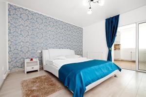 ein Schlafzimmer mit einem Bett und einer blauen Wand in der Unterkunft Blue Studio in Galaţi