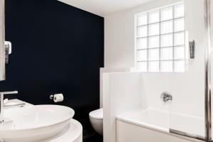 a bathroom with a white sink and a toilet at Hôtel Le Windsor Biarritz in Biarritz +34 photos