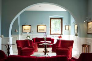an archway with red chairs and a table in a room at Hotel Riviera & Maximilian's in Trieste