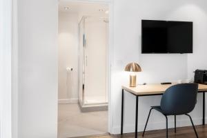 a room with a desk and a chair and a television at Hôtel Le Windsor Biarritz in Biarritz