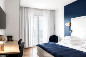 a bedroom with a bed and a desk and a chair at Hôtel Le Windsor Biarritz in Biarritz
