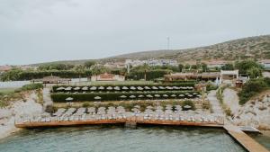 a group of chairs and umbrellas on a bridge in the water at Pırıl Hotel Thermal&Beauty SPA in Cesme