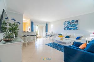 een woonkamer met een bank en een tafel bij Vila da Praia - Apartamento Viva Local in Alvor