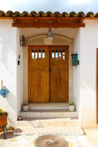 eine Holztür eines Hauses mit einer Veranda in der Unterkunft Renovated Wine Press House - WITH POOL in Porto de Mós