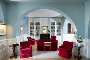 a living room with red chairs and an archway at Hotel Riviera & Maximilian's in Trieste