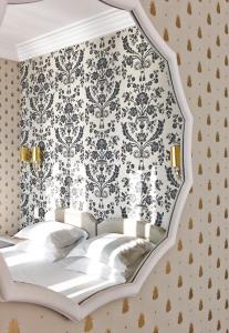 a bedroom with a bed with a damask wallpaper at Hôtel Belles Rives in Juan-les-Pins