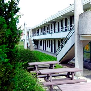 une rangée de bancs devant un bâtiment dans l'établissement Premiere Classe Lille Sud - Douai Cuincy, à Cuincy