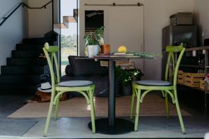 a table and two green chairs in a living room at Barn Hives Yallingup in Yallingup