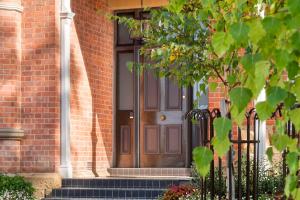 a brown door on a brick house with stairs at The Rivulet in Hobart