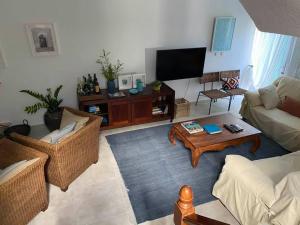 a living room with two couches and a tv at Casa das Cores in Sesimbra