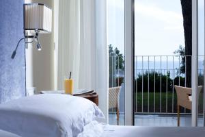 a bedroom with a bed and a balcony at Hotel Riviera & Maximilian's in Trieste