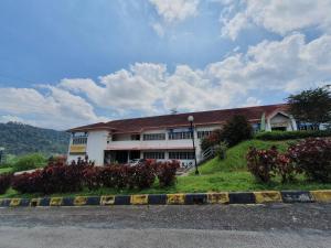 a white building with a red roof and some flowers at Selesa Hillhomes Golf Resort - M6GP in Bentong