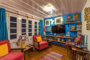 a living room with blue walls and red chairs at StayVista at Violet Hill in Shimla