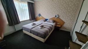 ein Hotelzimmer mit einem Bett mit Schuhen darauf in der Unterkunft Rumpenerhof in Brunssum