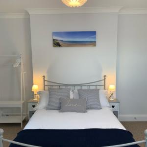 a bedroom with a large white bed with pillows at Seaspray Boutique Whitby Apartment in Whitby