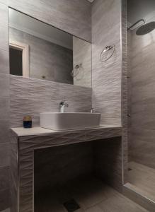 a bathroom with a sink and a mirror at Estell apartments in Sykia Chalkidikis +35 photos