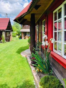 una casa rossa con fiori bianchi davanti di Садиба "ОРНАМЕНТ" a Szack