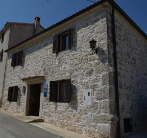 un edificio de piedra con ventanas y una calle en Casa Ferata - holiday home, en Vižinada