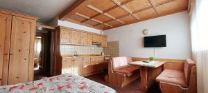 Valles Vacanze في فالكادي: غرفة مع مطبخ مع طاولة وتلفزيون