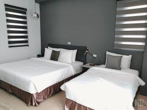 two beds sitting next to each other in a bedroom at 禾旅宿Ho Hostel 墾丁夢幻島 in Hengchun South Gate