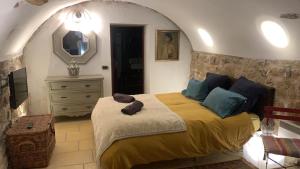 a bedroom with a bed and a mirror and a dresser at la villageoise, chambre troglodyte pitoresque au cœur du village in Rognes
