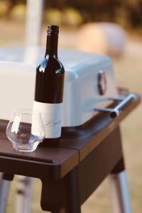 Barn Hives Yallingup في يالينجاب: زجاجة من النبيذ وكأس على الطاولة