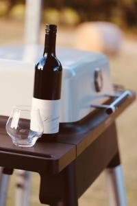 a bottle of wine and a glass on a table at Barn Hives Yallingup in Yallingup