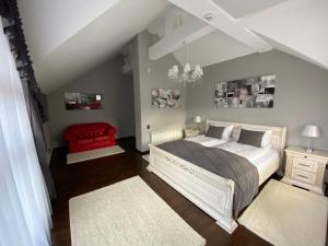 a bedroom with a large bed and a red chair at Hostynnyy Dvir Apartament Hotel & SPA in Slavske