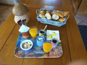 een dienblad met ontbijtproducten en sinaasappelsap op een tafel bij Cocon de St Pierre in Sainte-Marie-aux-Mines