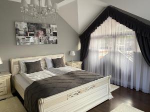 a bedroom with a bed with a chandelier and a window at Hostynnyy Dvir Apartament Hotel & SPA in Slavske