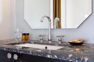 a kitchen counter with a sink and a mirror at Missori Suites in Milan