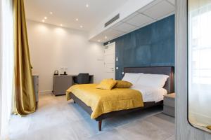 a bedroom with a bed with a yellow blanket at Missori Suites in Milan