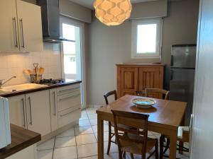 a kitchen with a wooden table and a dining room at Appartement Standing 55m2 - Terrasse Sud, Parking, Wifi in Aix-les-Bains