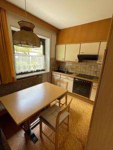 cocina con mesa de madera, sillas y ventana en Appartements Residence Ganthaler, en Rablà