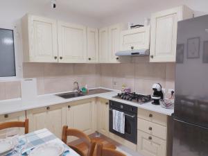 a kitchen with white cabinets and a stove top oven at Camera matrimoniale Genova rooms in Genova