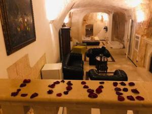 un soggiorno con tavolo e rose sopra di Alla dimora di Chiara Suite and Rooms a Matera