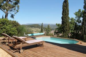 - une piscine sur une terrasse en bois avec 2 chaises et une table dans l'établissement Aux Deux Cedres, au Beausset