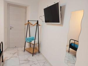 sala de estar con TV de pantalla plana en la pared en Camera matrimoniale Genova rooms en Génova